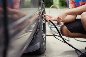 Man driver checking air pressure and filling air - NOLA Automotive Repairs
